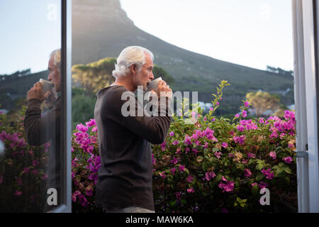 Älterer mann Kaffee auf dem Balkon Stockfoto