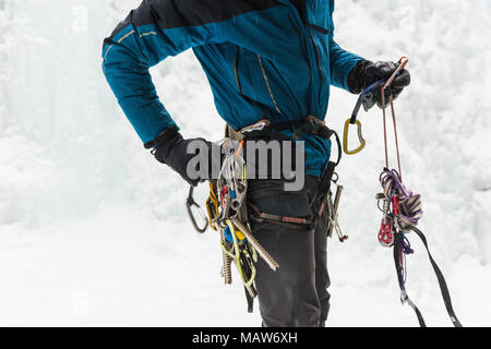 Männliche Kletterer tragen Kabelbaum in der Nähe von Rocky Mountain im Winter Stockfoto