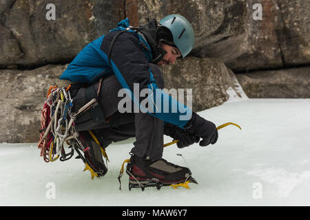 Männliche Kletterer tragen Steigeisen in der Nähe von Rocky Mountain Stockfoto