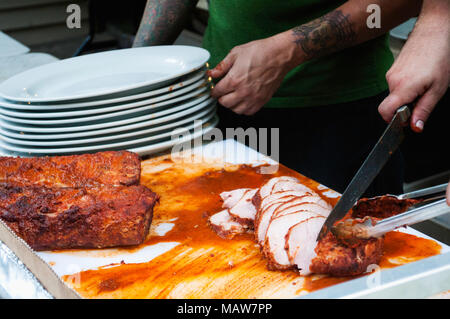 Vorbereitung BBQ Schweinelende für eine große Gruppe von Menschen. Stockfoto