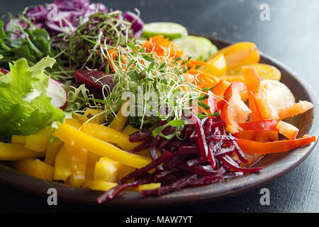 Gesundes Frühstück Salat mit Gemüse und microgreen auf dunklem Hintergrund. Sauber Essen vegetarische Diät gesunde Ernährung Konzept. Close Up. Stockfoto