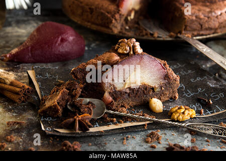 Stück Schokoladentorte mit Birnen in Rotwein geschmort, Haselnüsse, Walnüsse. Traditionelle Dessert. Close Up. Stockfoto