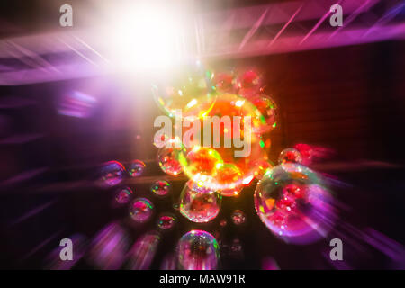 Abstraktes Bild von Seifenblasen aus der Blase Gebläse in Dunkelheit mit einem hellen Licht im Hintergrund. Stockfoto