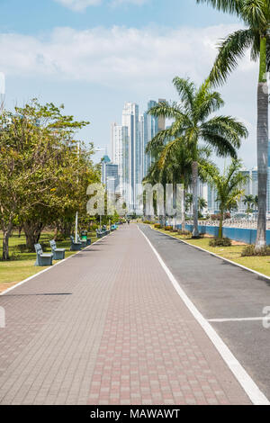 Bürgersteig an öffentlichen Park mit Skyline der Stadt an der Uferpromenade in Panama City Stockfoto