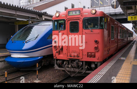 Eine heiße Serie 7000 Super Hakuto Express und KiHa Serie 40 Nahverkehrszüge in Kurayoshi Station auf dem Sanin in der Präfektur Tottori, Japan. Stockfoto