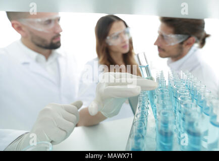 Hintergrund ist eine Gruppe von Wissenschaftlern, die studieren, die Flüssigkeit im Glas Rohr. Stockfoto