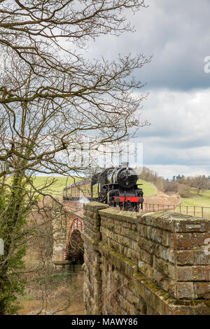 Vorderansicht der Alten, vintage UK Dampflok43106 (LMS Ivatt Klasse 4) anfahren, puffing Rauch, durch die malerische Landschaft im Frühling reisen. Stockfoto