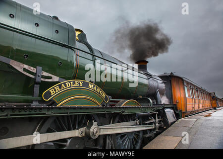 Die Severn Valley Railway Dampflokomotive Bradley Manor Nr. 7802 mit ihren Rechen aus lackiertem Teakholz Wagen wartet auf Abfahrt Kidderminster station. Stockfoto