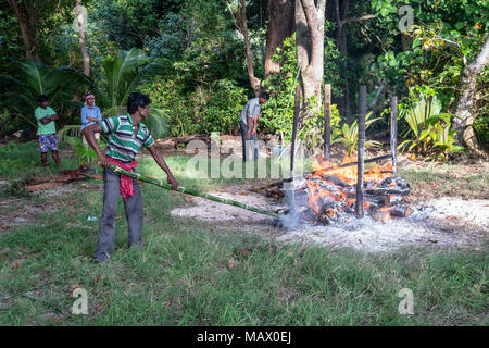 Prozess der Verbrennung in der Andamanen und Nikobaren. Hindu Traditionen. Die Inselbewohner des Verstorbenen auf dem Lagerfeuer am Ufer des t verbrannt Stockfoto