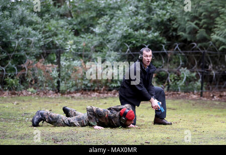 Ein Mitglied der Close Protection Unit Royal Military Police (rechts) schützt ein Delegierter spielen ein VIP als Teil einer Demonstration während der NATO-Militär Polizei Close Protection Konferenz an longmoor Trainingslager in Hampshire. Stockfoto