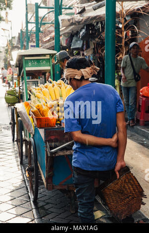 In Ubud, Indonesien - 8. März 2016: Anbieter verkauft gegrilltem Mais am Nyepi Day Festival in Ubud, Bali, Indonesien am März 08, 2016. Stockfoto