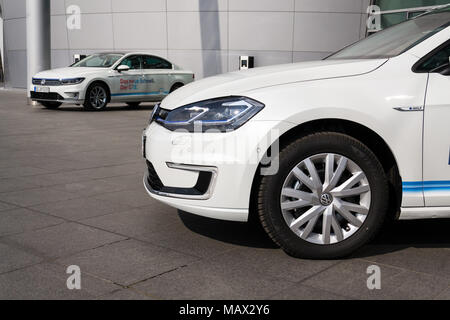 DRESDEN, Deutschland - 2. APRIL 2018: Plug-in-Hybrid Volkswagen Golf GTE und e-Golf Elektroautos stehen durch die Ladestation vor dem Glaserne Manufa Stockfoto