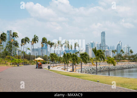 Bürgersteig an öffentlichen Park mit Skyline der Stadt an der Uferpromenade in Panama City Stockfoto