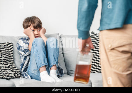 Junge Vater und Sohn erschrocken alkoholische zu Hause auf dem Sofa sitzen an seinem Vati sorgfältig close-up Stockfoto