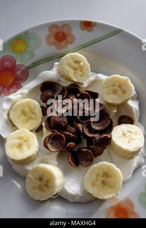 Gesundes Frühstück. Griechischer Joghurt mit Banane und Schokolade Weizen Getreide Stockfoto