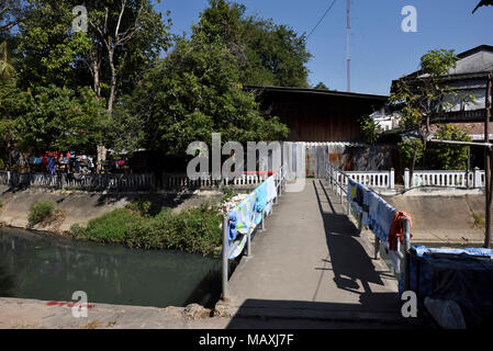 Frische Wäsche trocknen auf einer Brücke über einen schmutzigen Kanal in Chiang Mai, Thailand Stockfoto