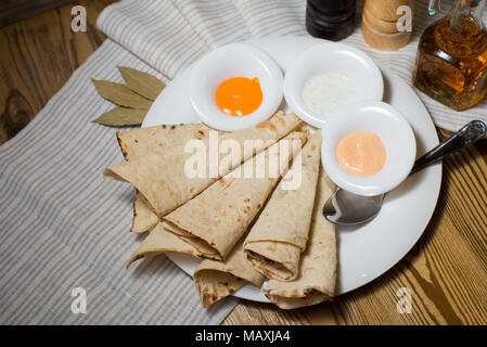 Brot runde dünne weiße mit Sauce auf einem weißen Teller auf dem Baum Stockfoto