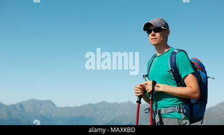 Bild von touristischen Mann in Sonnenbrille mit Stöcken Stockfoto