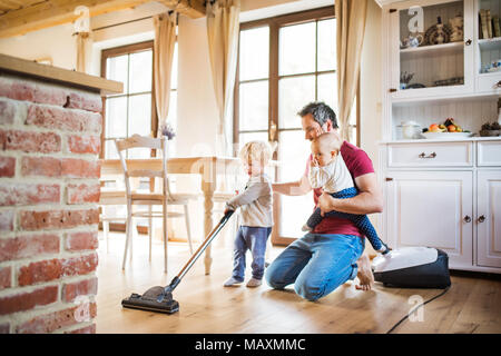 Vater und zwei Kleinkinder Hausarbeit tun. Stockfoto