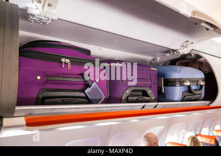 Handgepäck und Koffer in den Kabinenschränken eines Passagierflugzeugs Stockfoto