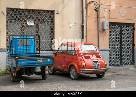 Eine alte Piaggio Ape und Fiat 500 außerhalb eines Gebäudes in Sizilien mit einem Schild, auf dem "Garage zu Vermieten' Stockfoto