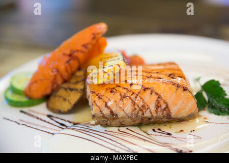 Gegrilltes Lachssteak und Gemüse in Weiß Teller im japanischen Restaurant. Stockfoto