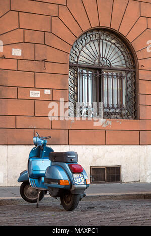 Einen alten berühmten blauen Piaggio PX 150 E Scooter auf einer gepflasterten Straße in Rom, Italien, geparkt. Stockfoto