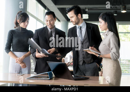 Smart Manager erklärt, internen Besprechung zu seinem Projekt Team im modernen Büro. Die multi-ethnische Geschäft Person Gruppe in Anzug. Projekt- und Business c
