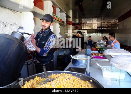 Östlichen Ghuta, Syrien. 5 Apr, 2018. Eine syrische Mann macht Humus und Falafel in der kürzlich eroberte Stadt Ayn Tarma im östlichen Ghuta Landschaft von Damaskus, Syrien, am 5. April 2018. Die letzten Rebellen- bereich in der Hauptstadt Damaskus' östliche Ghuta Landschaft ist um mich zu Fall zu bringen, mit einem neuen Abkommen, die die Evakuierung der Rebellen der Islam Armee in Richtung Norden Syriens. Credit: Ammar Safarjalani/Xinhua/Alamy leben Nachrichten Stockfoto