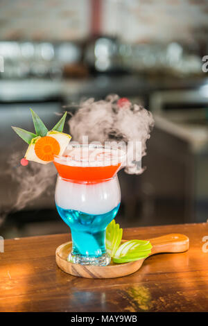 Cocktail mit Rauch mit einigen Scheiben green apple in Holz- Platte auf Holz- Cocktail Bar eingerichtet Stockfoto