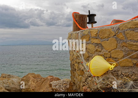 Gelbe Boje auf der Wand, fischnetz und Stütze Stockfoto