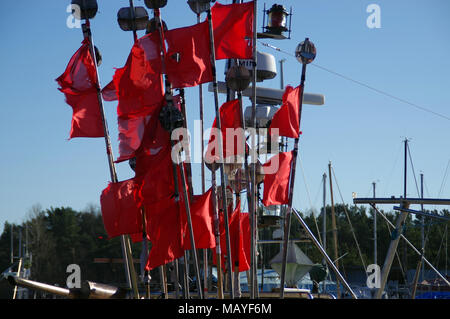 Eine zerklüftete rote Fahnen im Wind auf Fischerboot Stockfoto