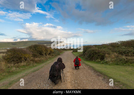 Zwei Fotografen mit Stativen in Seaford fotografieren die klassische Ansicht der Sieben Schwestern Kreidefelsen auf der South Downs Way, East Sussex, UK. Stockfoto