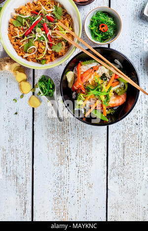Asiatische Huhn und Garnelen Curry mit Reis und frisches Gemüse, Ansicht von oben, auf alten Holzbrettern serviert. Stockfoto