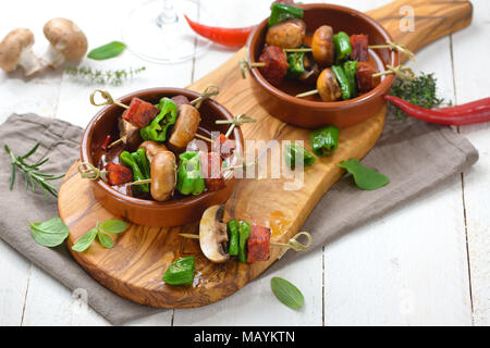 Spanisch Snack: Pincho Spieße mit gebratener Chorizo Wurst, pimientos de Padron und Pilze Stockfoto