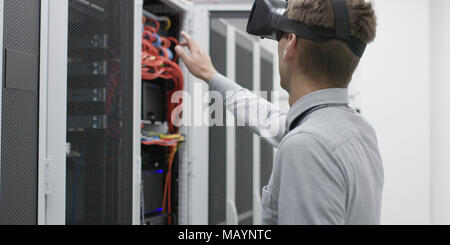 Techniker mit Laptop, während Server Analyse im Server Raum Stockfoto