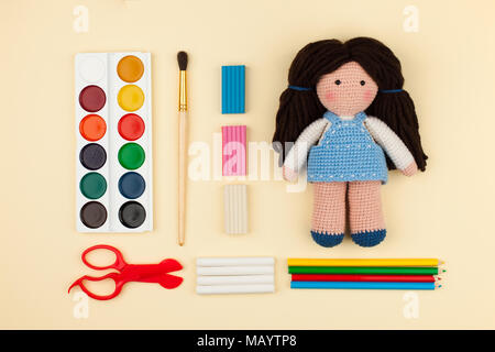 Oder Puppe mit braunen Haaren, Aquarelle, Bürsten Papier auf einem gelben Hintergrund, das Konzept von Urlaub, Kreativität und die Entwicklung der Kinder Stockfoto