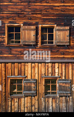 Holz- Wand mit Fenstern auf einer Almhütte, Tirol, Österreich Stockfoto