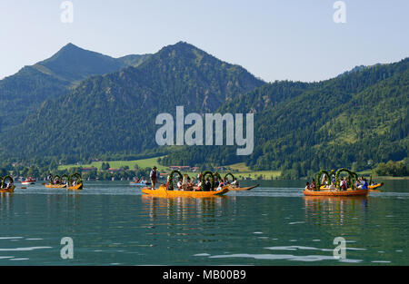 Männer tragen traditionelle Kostüme im festlich geschmückten Plätzen, Boote aus Holz, auf der Schliersee See, hinter Brecherspitze Stockfoto