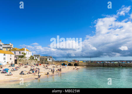 Urlauber entspannen auf St Ives Harbour Beach in Cornwall. Stockfoto