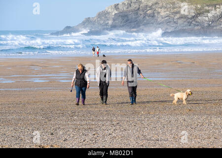 Eine Familie zu Fuß ihren Hund am Strand von Holywell Bay in Newquay in Cornwall. Stockfoto