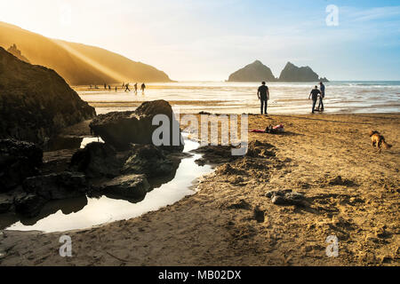 Ebbe und die untergehende Sonne bei Holywell Bay in Newquay in Cornwall. Stockfoto