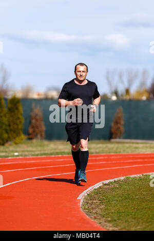 Männliche sprinter im mittleren Alter Züge für Race Bewerb Stockfoto