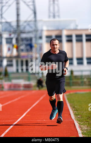 Männliche sprinter im mittleren Alter Züge für Race Bewerb Stockfoto