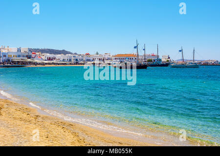 MYKONOS, Griechenland - 23. Mai 2017: Sandstrand und Fischerboote im Hafen von Mykonos, Kykladen, Griechenland Stockfoto