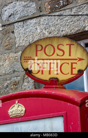 Eine alte vintage Post oder Postdienste Wegweiser auf der Oberseite eines traditionellen roten gpo Post Office Phone Box. Englisch typisch britisch Telefon. Stockfoto