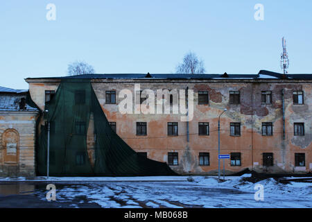 Teilweise Gebäude mesh mit Falten gefallen, schützen das alte Haus mit einem verputzten Wand. Stockfoto
