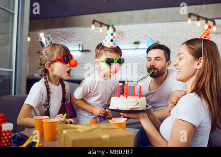 Eine glückliche Familie mit einem Kuchen feiert Geburtstag. Stockfoto