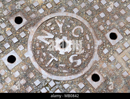 Kanaldeckel auf der Straße in Manhattan, New York, verwendet, alte Wasserwege, die Kanalisation und die Kohle rutschen zu decken Stockfoto