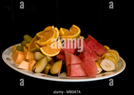 Eine Platte mit frisches Obst auf einem schwarzen Hintergrund. Stockfoto
